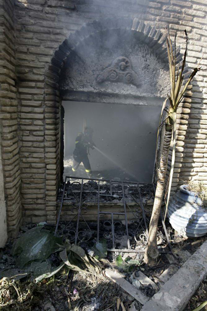 Пожарный тушит дом изнутри в Марафоне к северу от Афин в воскресенье. (Icon/Reuters)