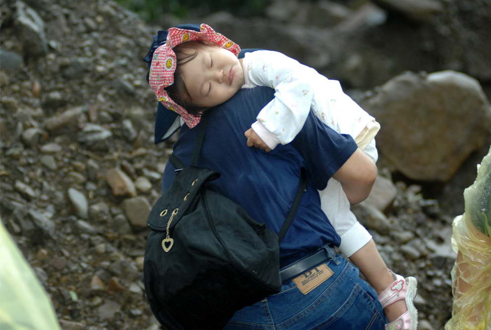 Девочку уносят из района оползней, вызванных тайфуном Моракот в Чиашине, округ Гаосюн, южный Тайвань 10 августа 2009 года. (PATRICK LIN/AFP/Getty Images)