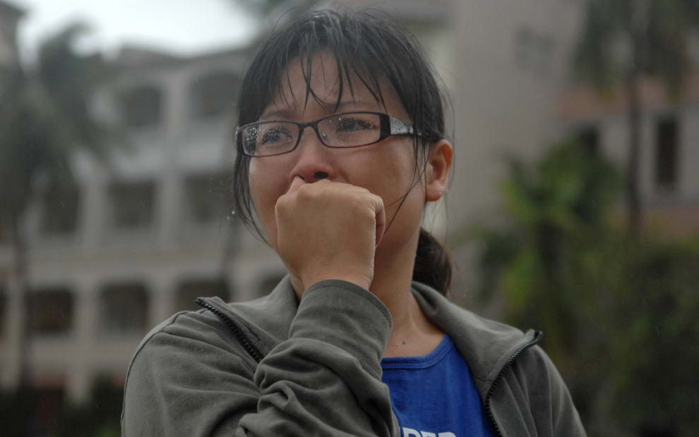 Напуганная женщина ждет в лагере для беженцев вестей о своем пропавшем отце из деревни Сяо Линь, на которую обрушились оползни, вызванные тайфуном Моракот в округе Гаосюн, южный Тайвань. Понедельник, 10 августа 2009. (AP Photo)