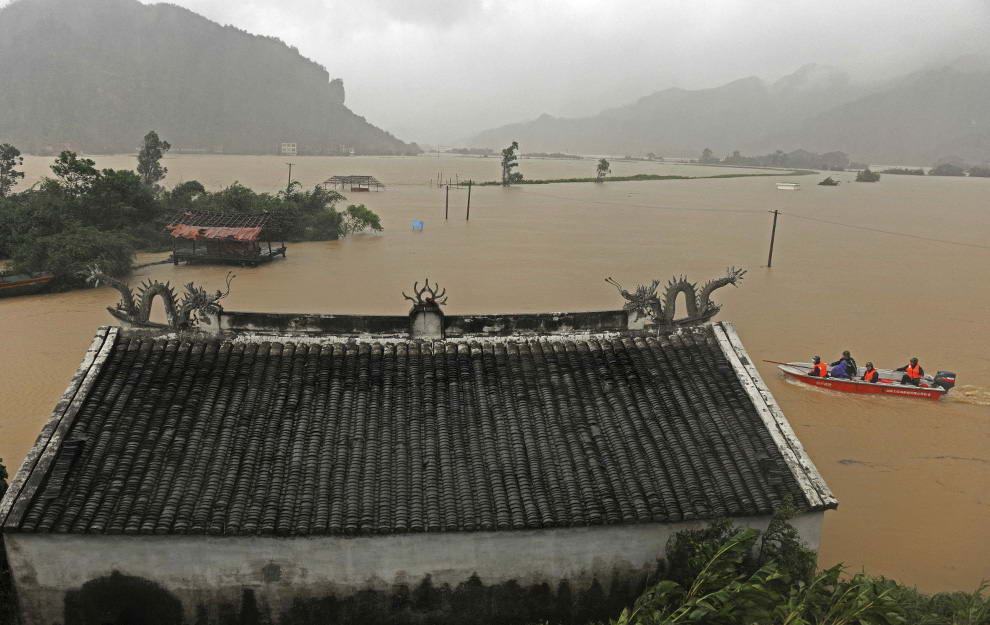 Военизированные полицейские прочесывают затопленную деревню на моторной лодке – округ Цаньнань, восточный Китай, воскресенье 9 августа 2009. (AP Photo)