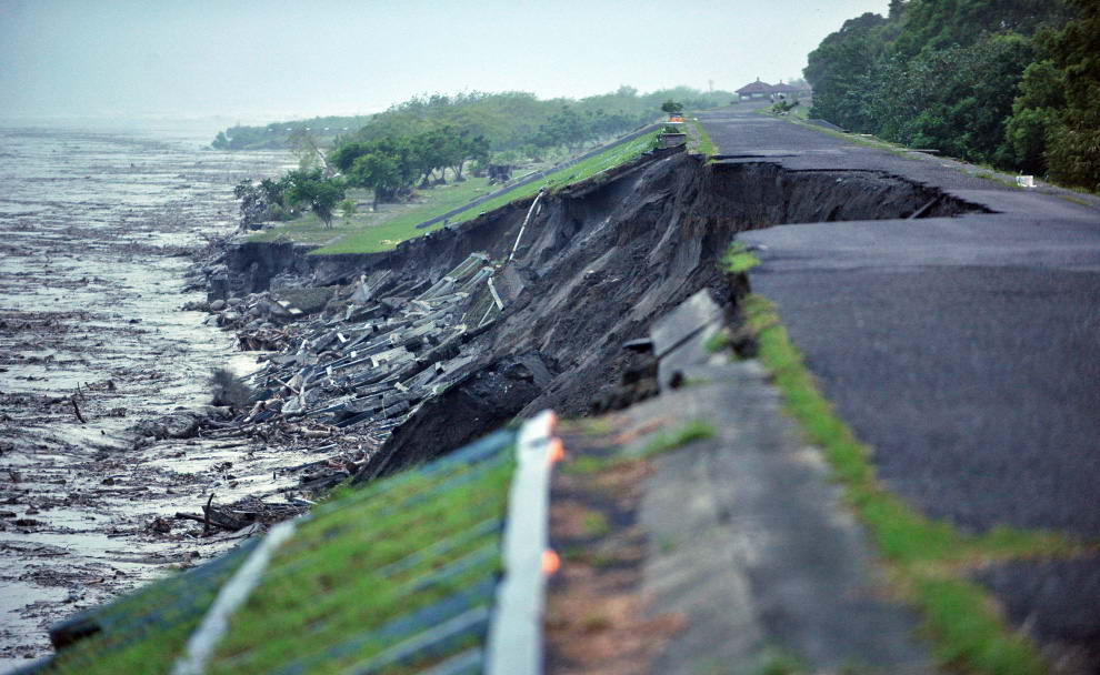 Вода бушует у сильно поврежденного берега недалеко от разрушенного моста, который раньше соединял Пиндун и Гаосюн, в южном Тайване 9 августа 2009. (SAM YEH/AFP/Getty Images)