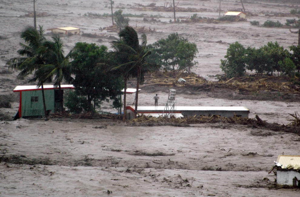Человек стоит на крыше в ожидании спасателей в затопленном городе Таймали к юго-востоку от Таитуна 8 августа 2009 во время тайфуна Моракот. (AFP/AFP/Getty Images)