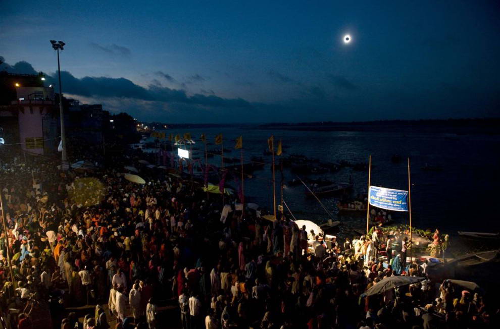 Тысячи людей собрались вдоль реки Ганг в индийском городке Варанаси, чтобы посмотреть на полное солнечное затмение, которое произошло 22 июля. Темный диск луны, полностью закрывший солнце, окружен тонким ореолом солнечной короны. (Pedro Ugarte/AFP - Getty Images)