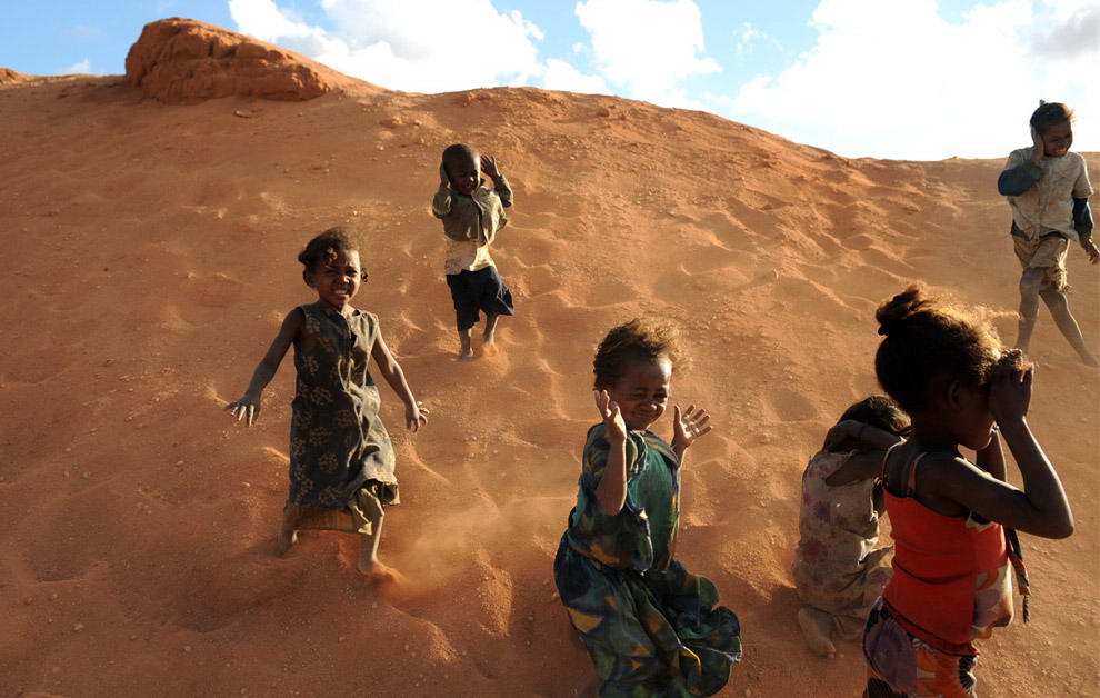 Ветер несет песок из сапфировой шахты в сторону детей, которые играют неподалеку от шахты