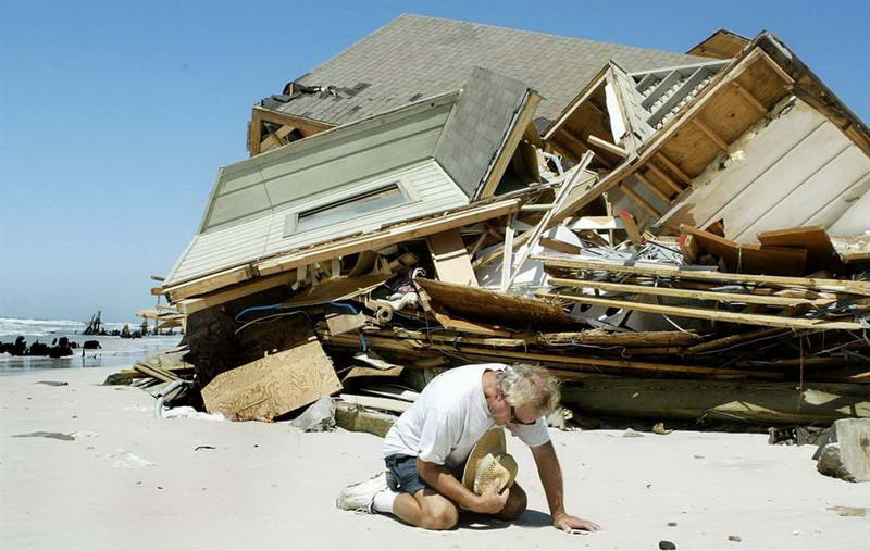 Владелец этого дома на Капе Сан Бласе, Флорида, молится после урагана Иван, разрушившего его дом и сотни подобных этому домов по всему побережью. 