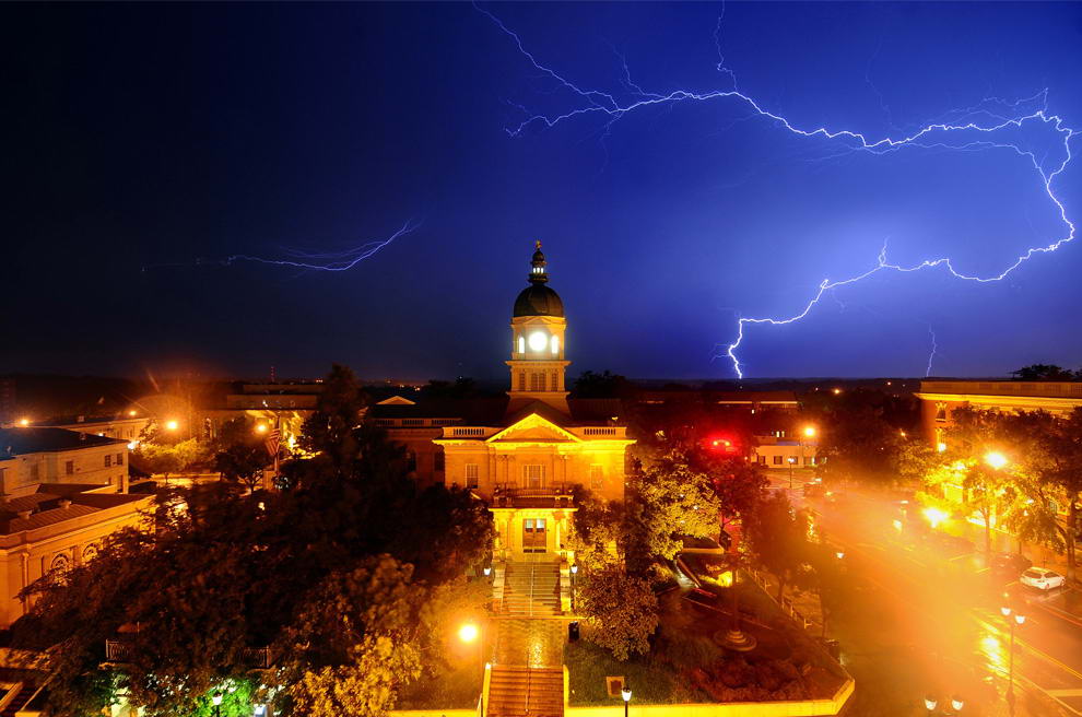 Молния освещает небо позади здания мэрии в городе Афины, штат Джорджия рано утром, 18 июня 2009. Более 4000 человек остались без света в Северо-Восточной Джорджии во время этой грозы. (AP Photo/The Athens Banner-Herald, Kelly Lambert)