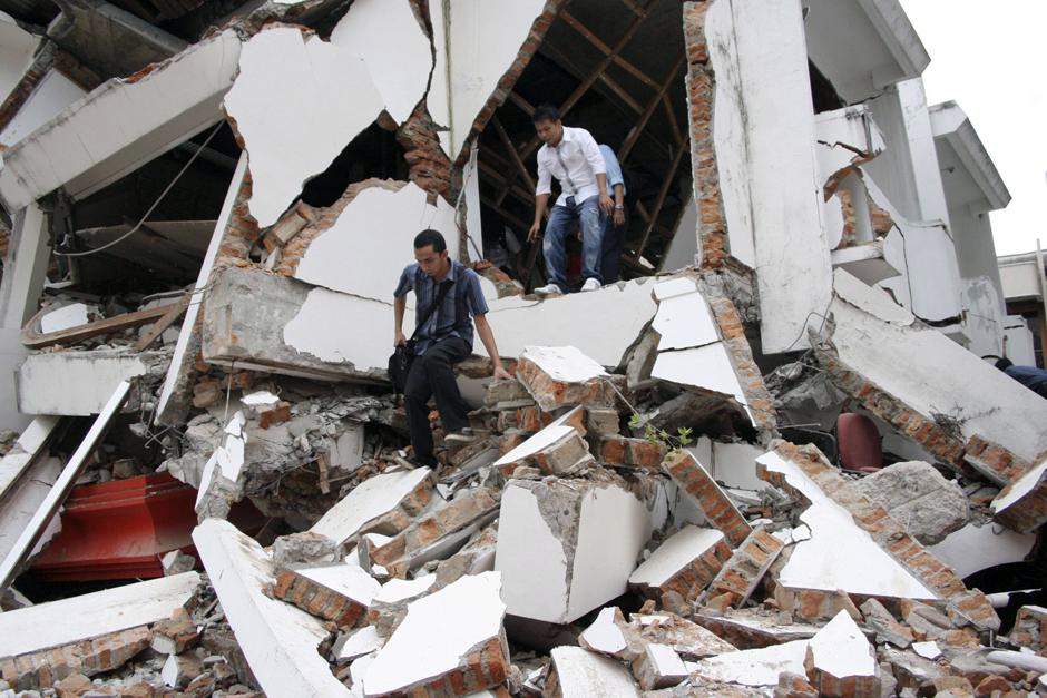 Студенты выходят из рухнувшего здания после землетрясения в Паданге, на острове Суматра в Индонезии. 