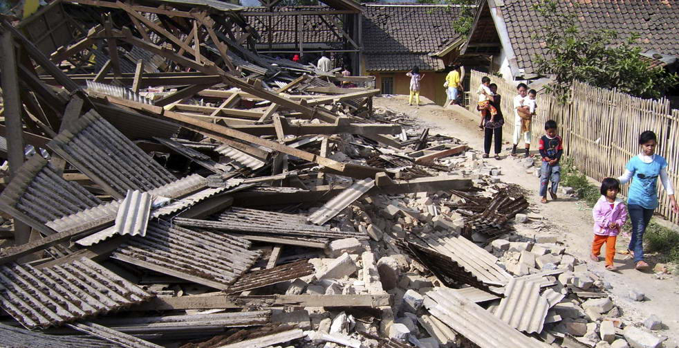 Жители проходят мимо развалин домов, разрушенных в результате землетрясения в Pengalengan, Западная Ява, Индонезия