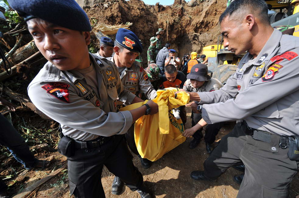 Индонезийские полицейские несут мертвые тела во время эвакуации в деревне Cikangkareng в Сибинонге 3 сентября. (AFP/Getty Images/ Adek Berry)