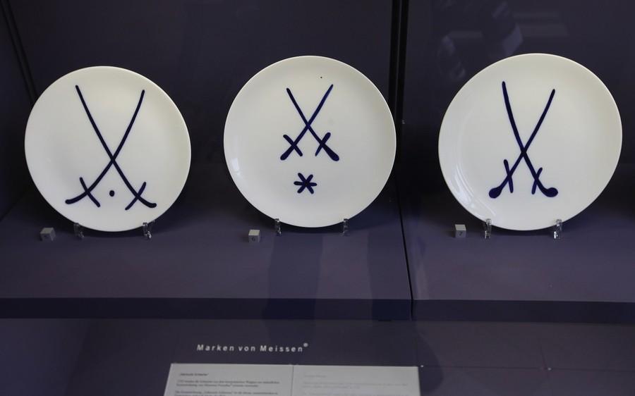 Логотип мейсенского завода по производству фарфоровых изделий – скрещенные мечи – на фарфоровых тарелках в музее Мейсена.