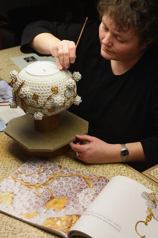 Художница Рамона Кестель рисует крошечные лепестки на изысканном чайнике на заводе в Мейсене.