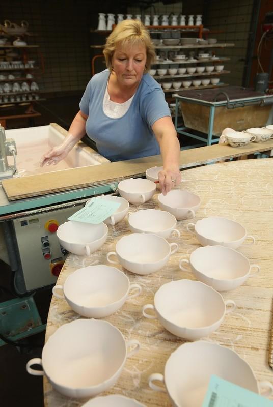 Художница готовит фарфоровые миски для глазирования на заводе немецкого фарфора в Мейсене.