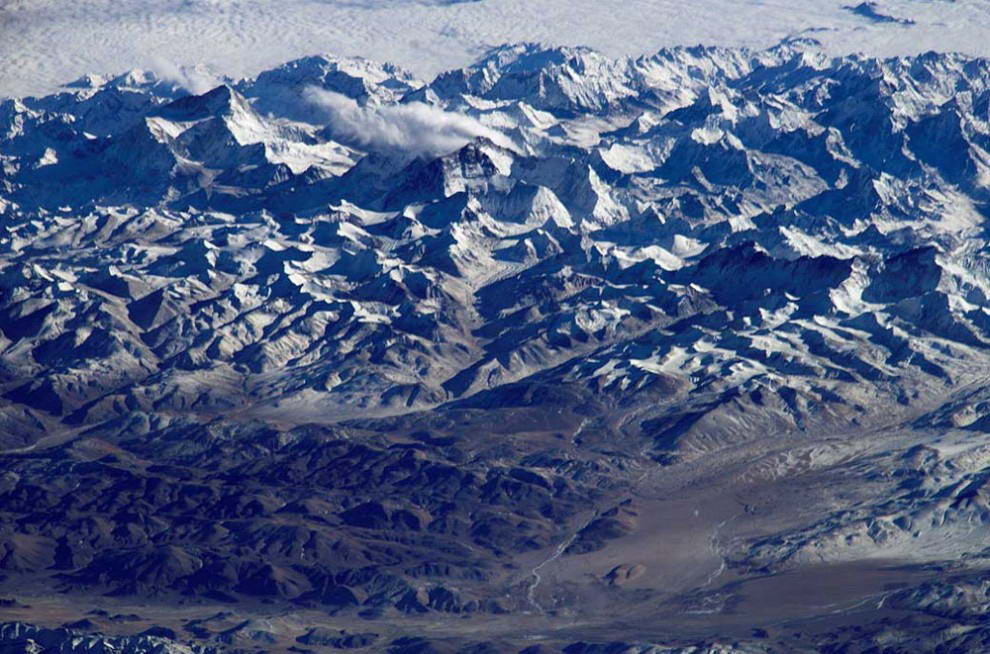 Взбираться по горам намного сложнее, чем спускаться на океанское дно, если смотреть на это со стороны гравитации. Притяжение Земли намного сильнее в горах, чем на плоской поверхности, а в океанских впадинах еще слабее. Наверху: гора Эверест в Гималаях. (NASA)