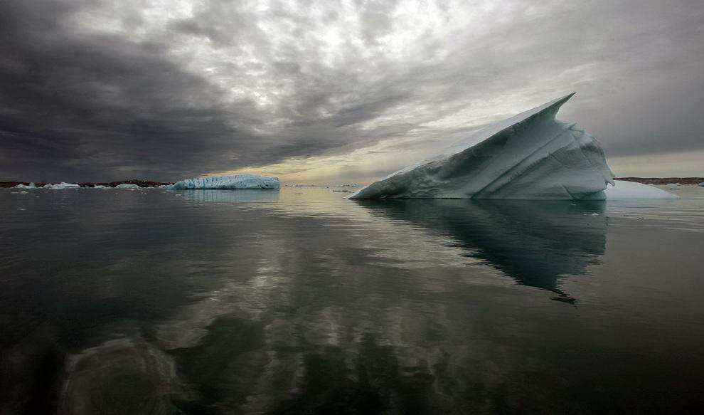 Айсберги плывут в спокойных водах фьорда к югу от города Тасиилак в восточной Гренландии 4 августа 2009 года. (REUTERS/Bob Strong)