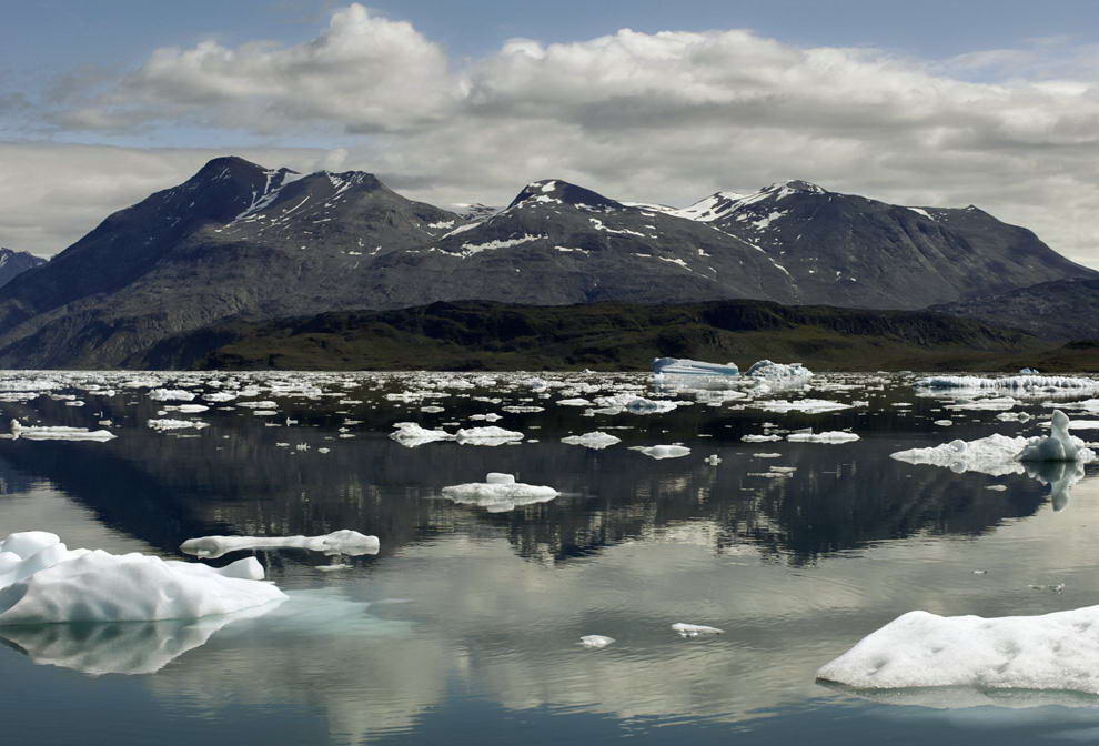 Айсберги отражаются в водах фьорда Эрик недалеко от города Нарсарсуак в южной Гренландии 26 июля 209 года. (REUTERS/Bob Strong)