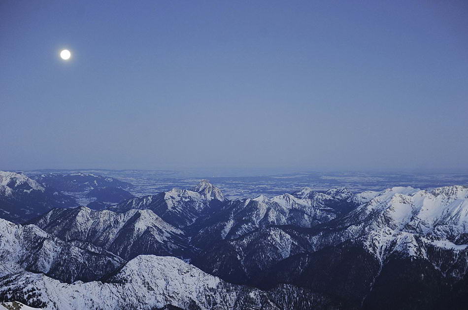 На этом снимке полная луна зависла над альпийской панорамой на пике Зугшпиц, Германия, как раз перед рассветом 11 января 2009 года. Перед самым рассветом альпинист-любитель отправился по канатной дороге на самую высокую точку в Германии на пронизывающем холоде. (Oliver Lang, AFP/Getty Images)