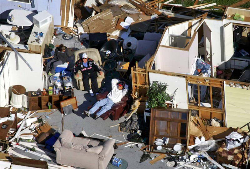 Мужчины сидят в разрушенном передвижном домике в Форт-Лодердейле, Филадельфия, 25 октября 2005, после урагана Вилма