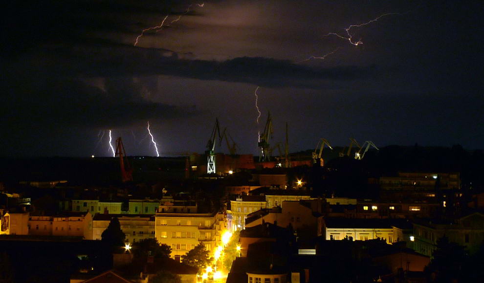 Вспышки молний освещают ночное небо во время летней грозы над хорватским адриатическим портом Пула 10 июля 2009. (REUTERS/Nikola Solic)