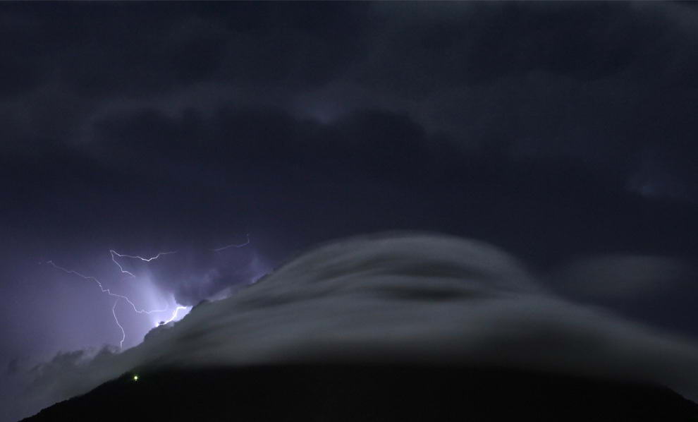 Молния бьет в грозовых облаках над вулканом Агуа в Антигуа, в 32 км от Гватемала-Сити 4 июля 2009. (REUTERS/Carlos Barria)
