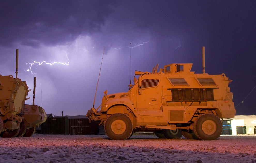 Молния во время грозы над бронемашиной с защитой от мин и внезапного нападения типа MRAP на территории американской оперативной базы в афганской провинции Логар 18 июля 2009. (REUTERS/Shamil Zhumatov)