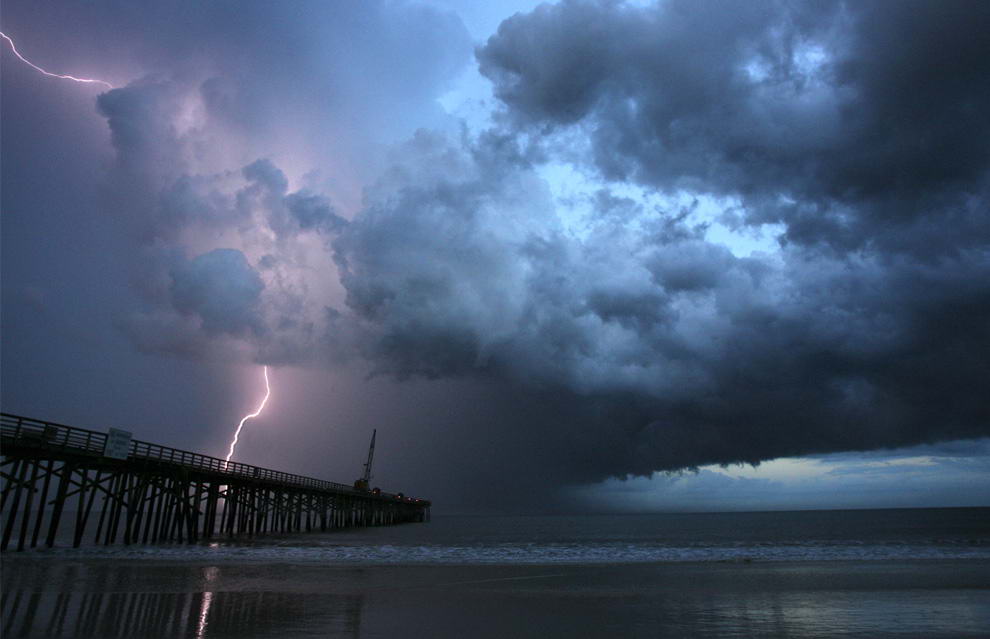 Молния бьет за пристанью Флаглер в Флаглер Бич, штат Флорида, во время летней бури 18 июля 2009. (AP Photo/Daytona Beach News-Journal/David Massey)