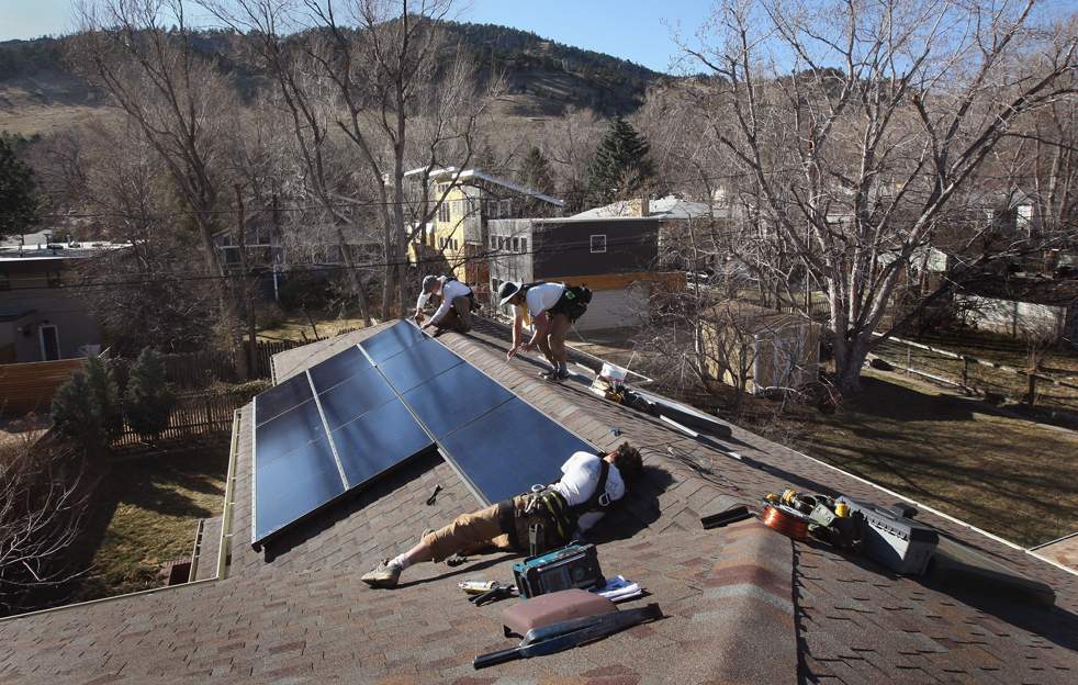 Работники компании «Namaste Solar» устанавливают солнечную панель на крышу дома 4 марта в Болдере, штат Колорадо. (Getty Images / John Moore)