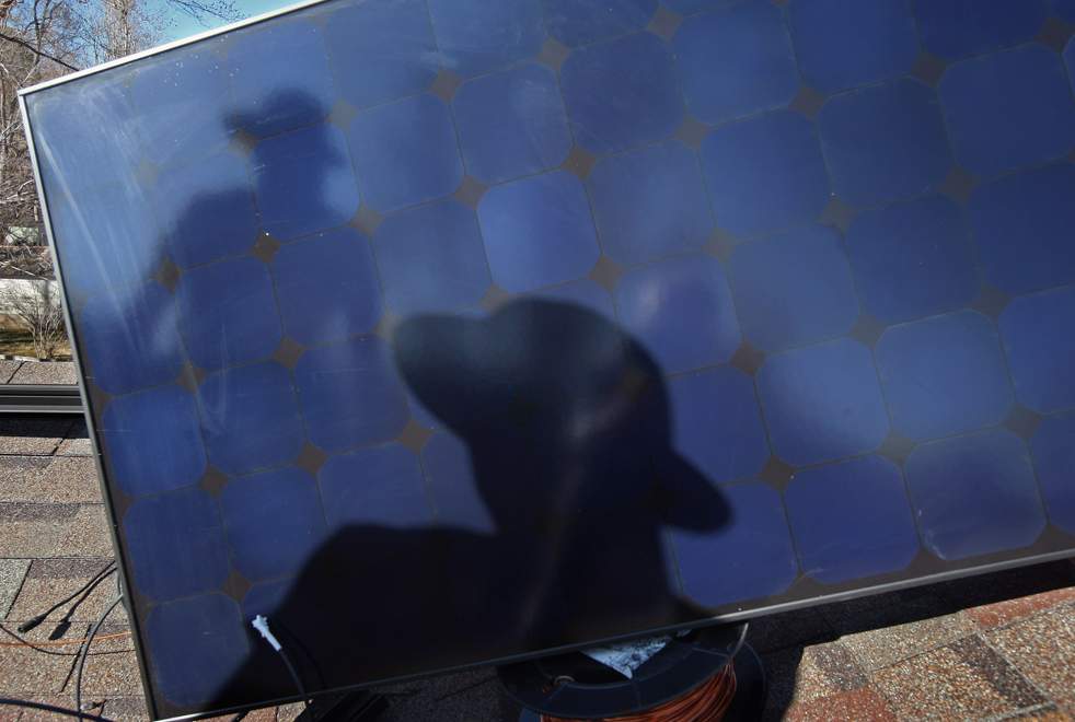Главный монтажник Гари Гантцер готовится поставить солнечную панель на крышу дома 4 марта в Болдере, штат Колорадо. (Getty Images / John Moore)