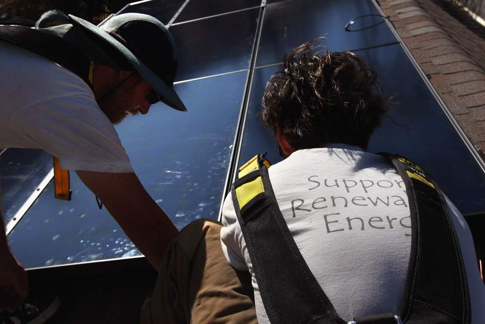 Монтажники из компании «Namaste Solar» ставят солнечную панель на крышу дома 4 марта в Болдере, штат Колорадо. Компании по выработке возобновляемой энергии (такие как  «Namaste») получат дополнительные фонды на создание «зеленых» инициатив из федерального пакета экономических стимулов. (Getty Images / John Moore)