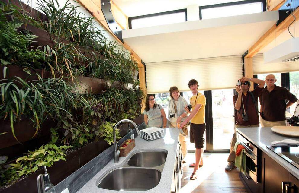 Посетители в доме команды из Пенсильвании с «живой» стеной из растений, которые можно использовать для приготовления пищи. (Stefano Paltera/U.S. Dept. of Energy)