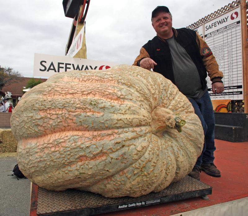 Дон Янг (слева) из Де Мойн, штат Айова опирается на свою 752 килограммовую тыкву после победы на конкурсе в Хаф Мун Бей 12 октября 2009 года. (UPI/Terry Schmitt)