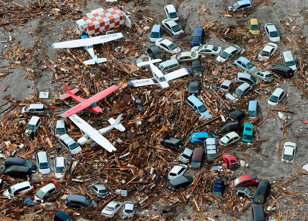 Смытые цунами автомобили и самолёты на территории аэропорта города Сендай (фото AP / Kyodo News).
