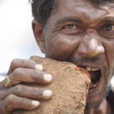 Индийский мужчина утоляет голод грязью и кирпичами